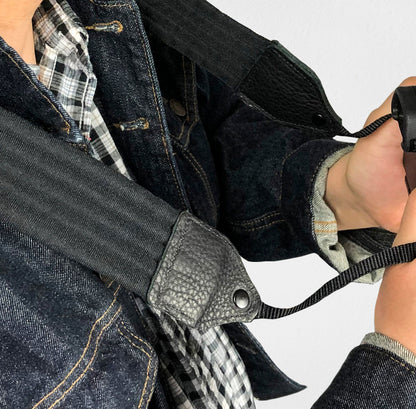 Black pleated nylon camera strap.