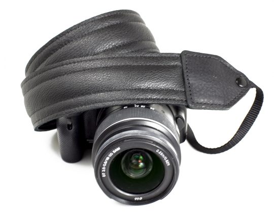 Black piped leather stitch camera strap.